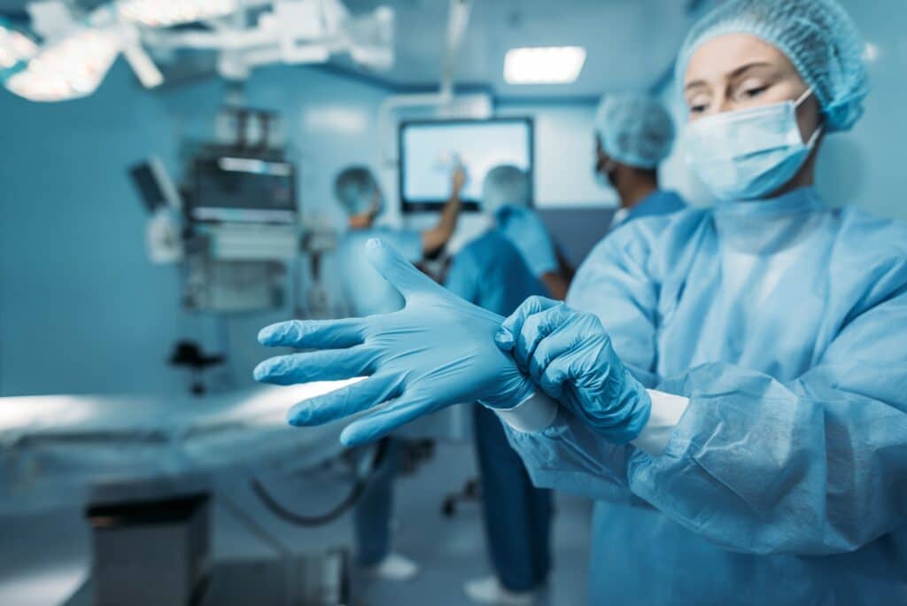 doctor wearing medical gloves in operating room